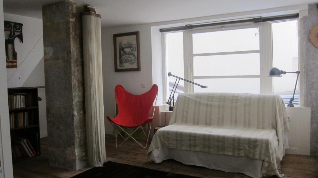 a living room with a red chair and a window at stipologic Duplex in Paris