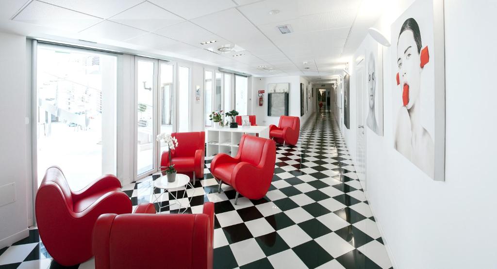 a waiting room with red chairs and a checkered floor at Hotel Studio Inn Centrale & Milano Urban Padel in Milan