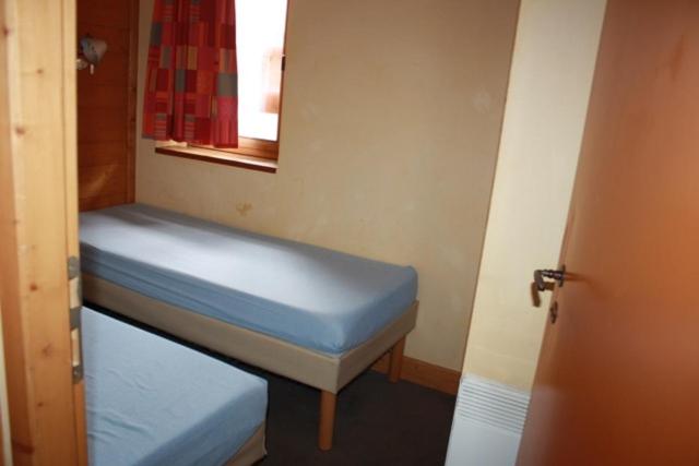 LʼHuezにあるL'ours blancの青いベッドと鏡が備わる小さな客室です。