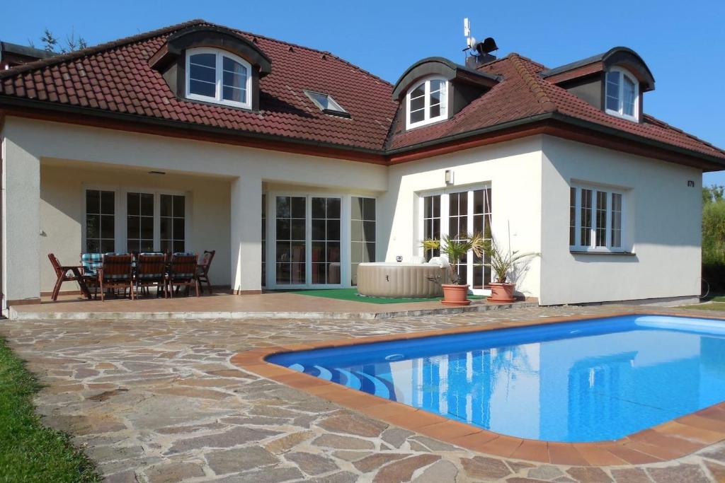 una casa con piscina frente a ella en Vila Plana nad Luznici en Planá nad Lužnicí