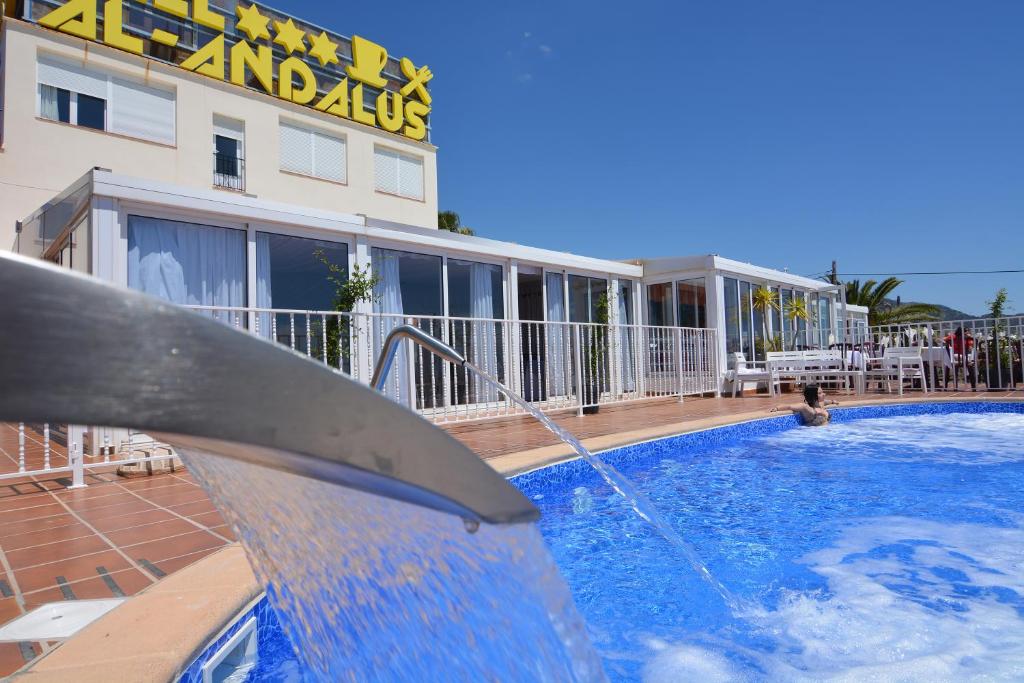 una piscina con una fuente de agua frente a un hotel en Hotel Al-Andalus en Nerja