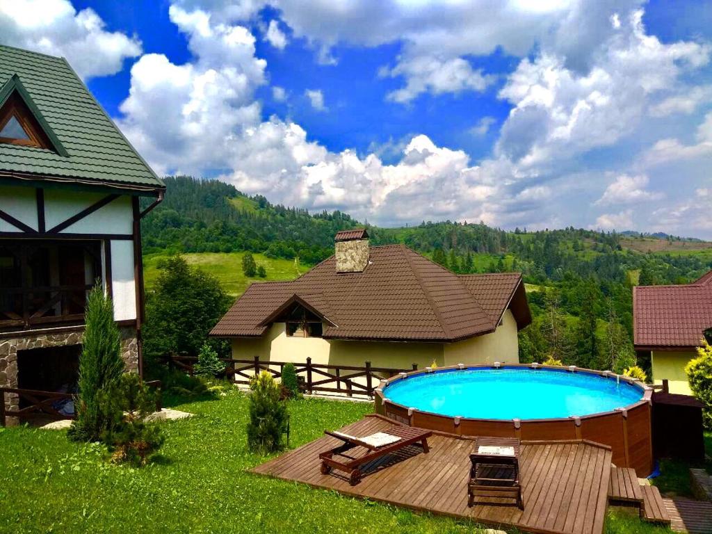 a backyard with a swimming pool and a house at Chalet Trostian in Slavske