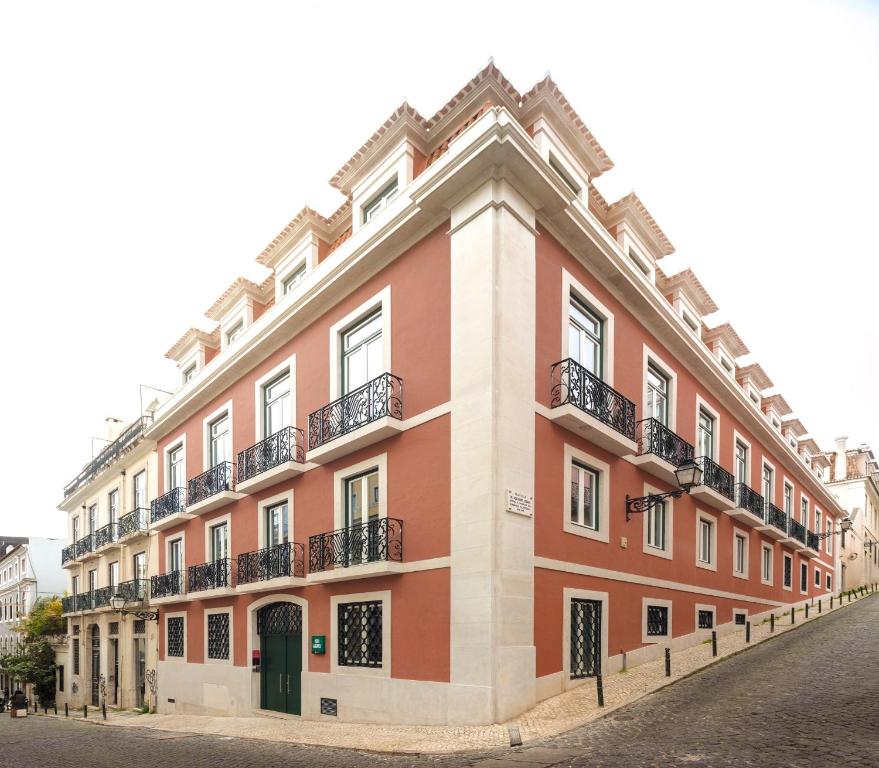 um grande edifício vermelho com varandas numa rua em Lisbon Serviced Apartments - Chiado Emenda em Lisboa
