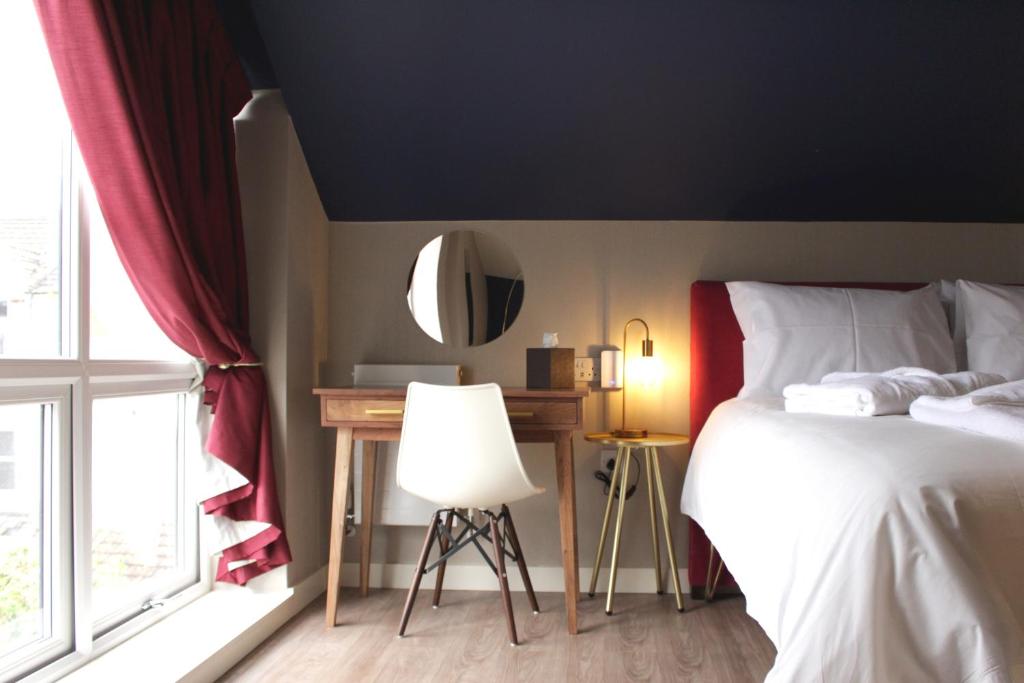1 dormitorio con cama, espejo y ventana en Aaron Wise - 62 Plantagenet Studios, en Cardiff