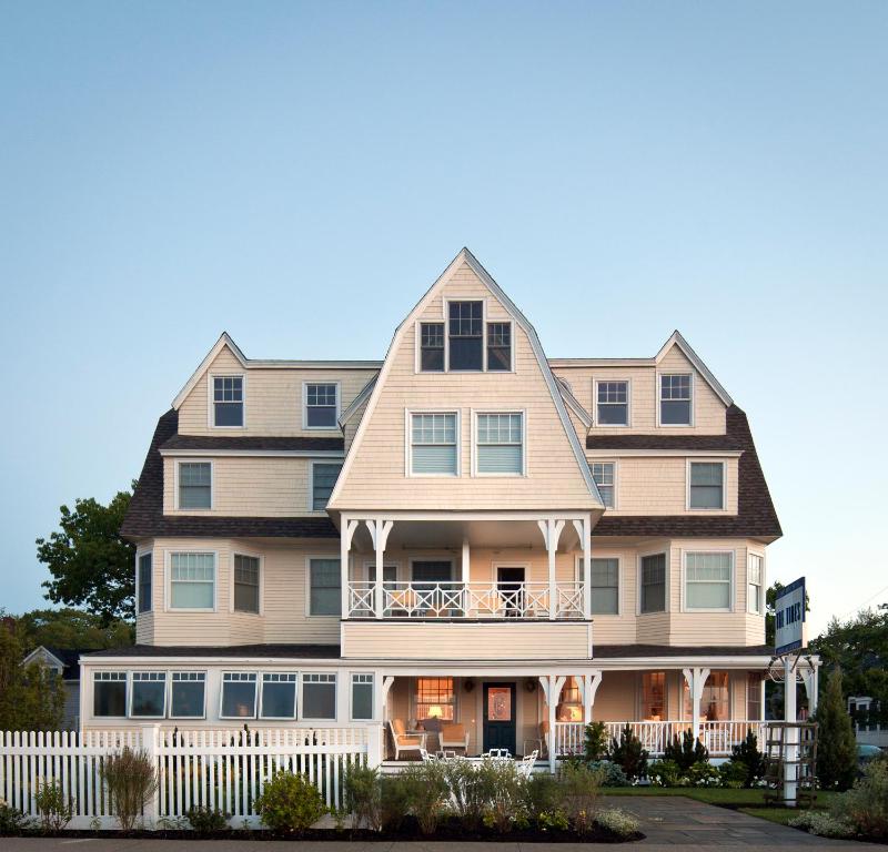 a large house with a white fence in front of it at The Tides Beach Club in Kennebunkport
