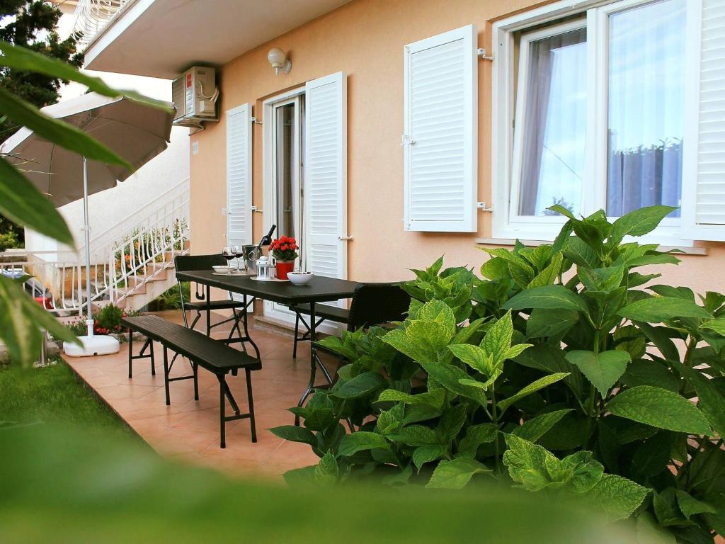 a patio with a table and chairs and plants at Apartman Ruza 1 in Poljane
