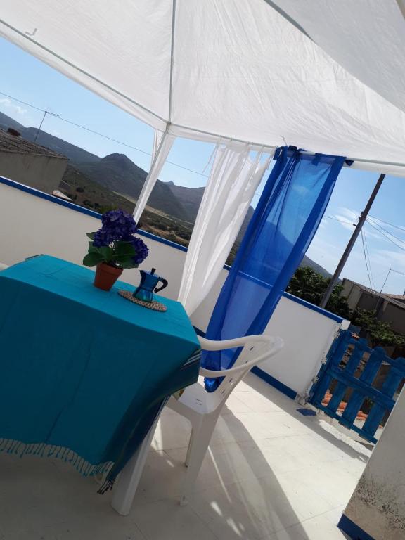 een blauwe tafel en een witte stoel op een balkon bij Casa Stella Marina in Carbonia