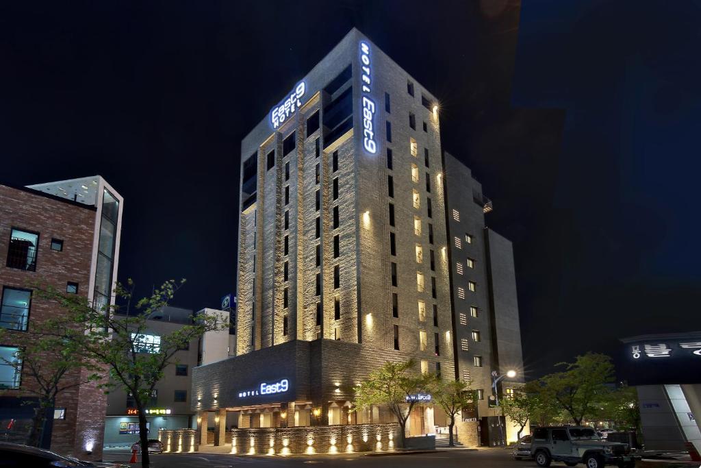 a tall building with lights on it at night at Hotel East9 in Gangneung