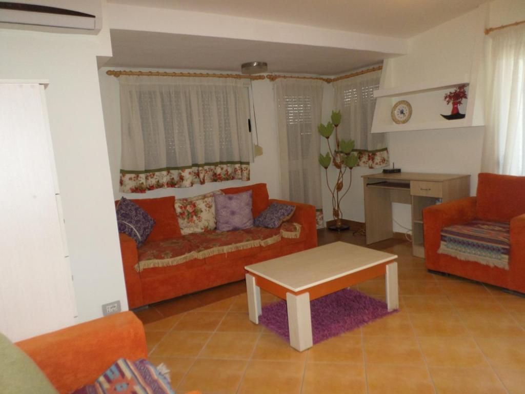 sala de estar con sofá y mesa en Aldom Apartments, en Durrës