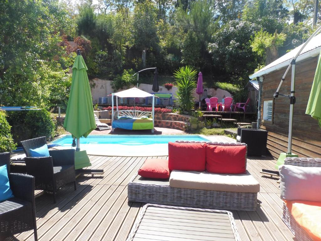 a patio with a couch and chairs next to a pool at La Kaz Ouale in Saint-Leu
