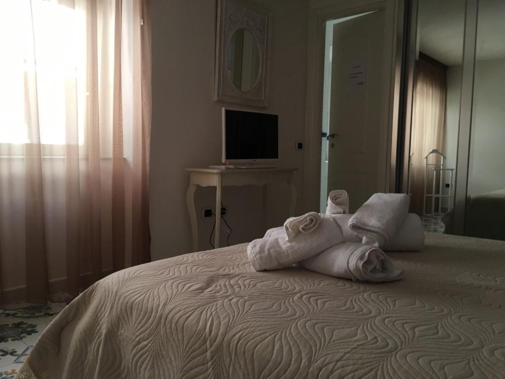 a bedroom with a bed with towels on it at La Corte del Re Borbone in Caserta