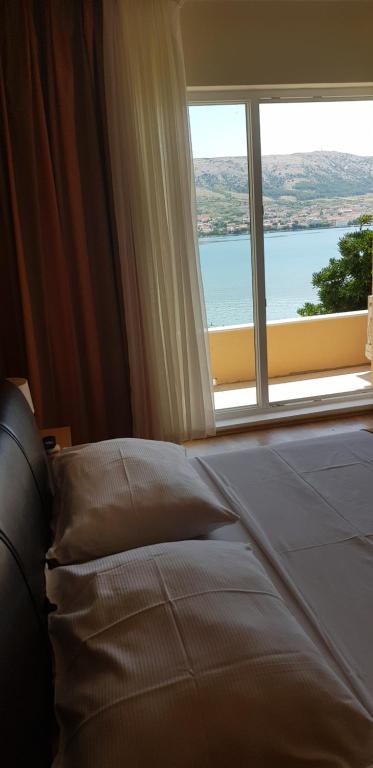 a bed in a room with a large window at Boutique Villa Revelin in Pag
