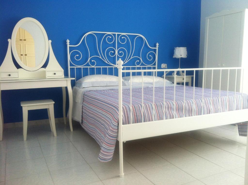 a blue bedroom with a bed and a mirror at la casa per le tue vacanze in Milazzo