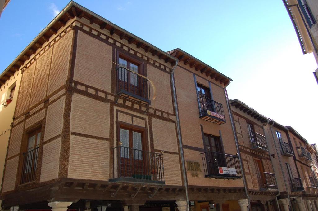 a brown building with balconies on the side of it at Hostal Mayor 71 in El Burgo de Osma