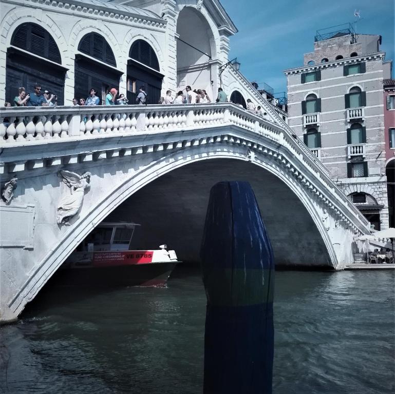 eine Brücke über einen Fluss mit einem Boot in der Unterkunft Casa Barzizza in Venedig