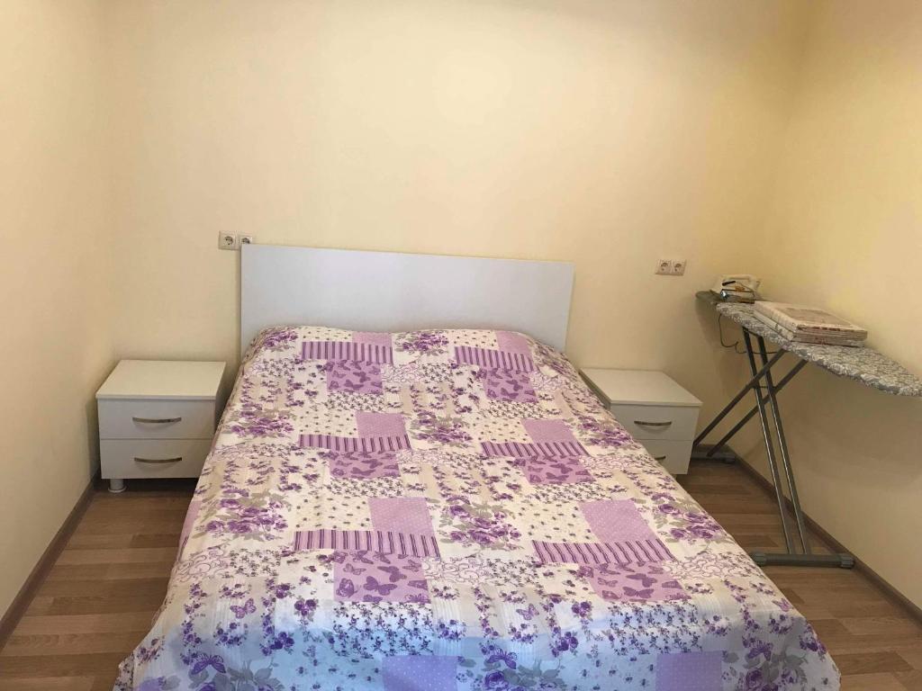 um quarto com uma cama com um edredão roxo e branco em Griboedovi N.6 em Batumi