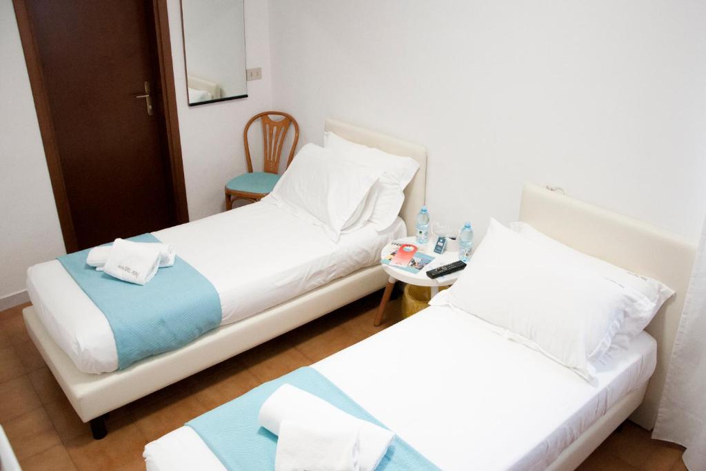 a hotel room with two beds and a table at Hotel del Mar in Sottomarina