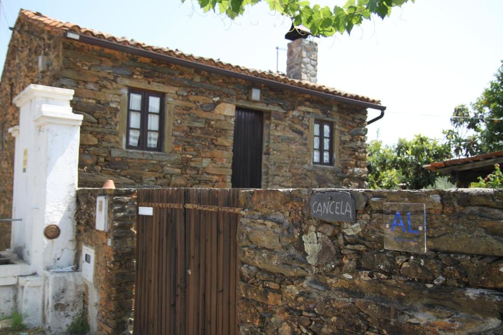 uma velha casa de pedra com uma cerca em frente em Aldeia Oliveiras em Sobreira Formosa