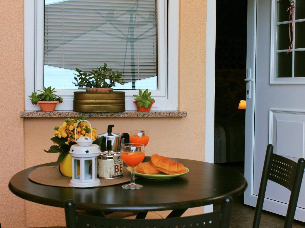 a table with a plate of bread and a drink at Apartman Ruza 3 in Poljane