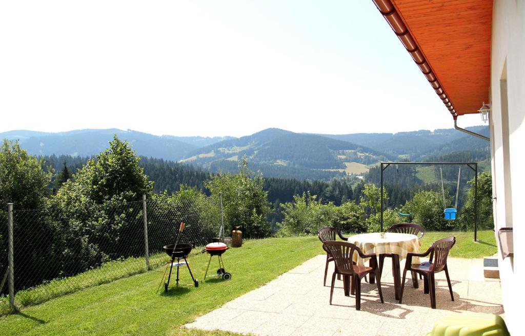 a patio with a table and chairs and mountains in the background at Apartmá Království Beskyd in Horní Bečva