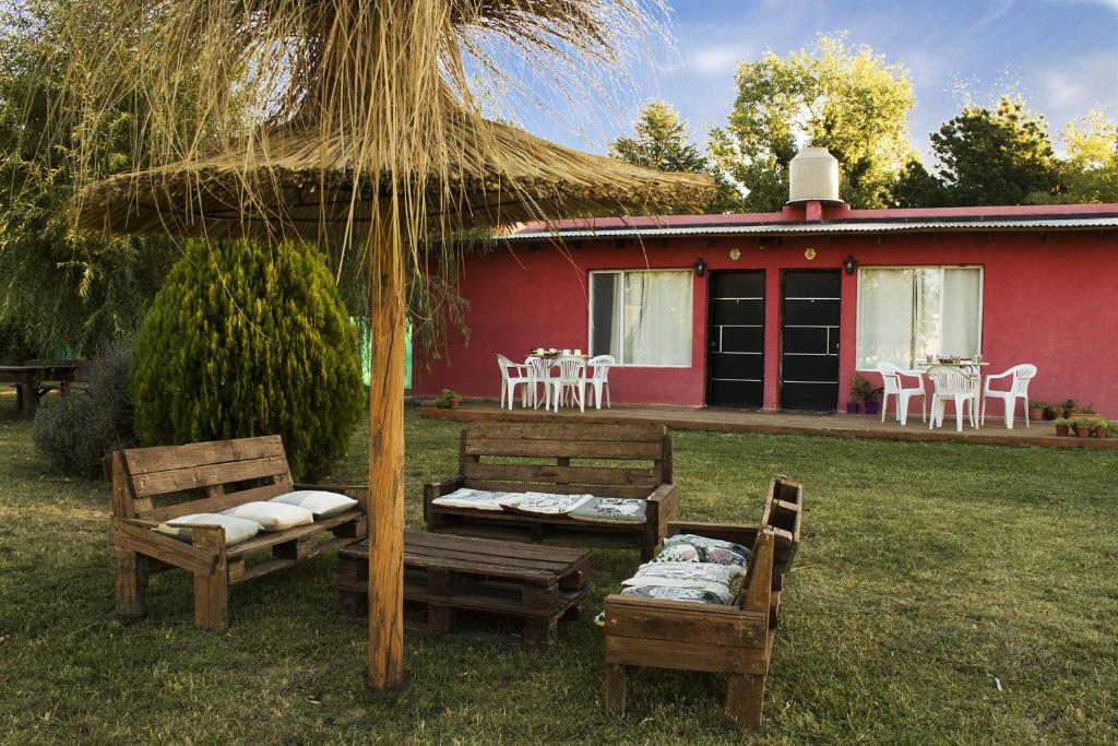 a house with two chairs and a table and an umbrella at Las Lechuzas in Tandil