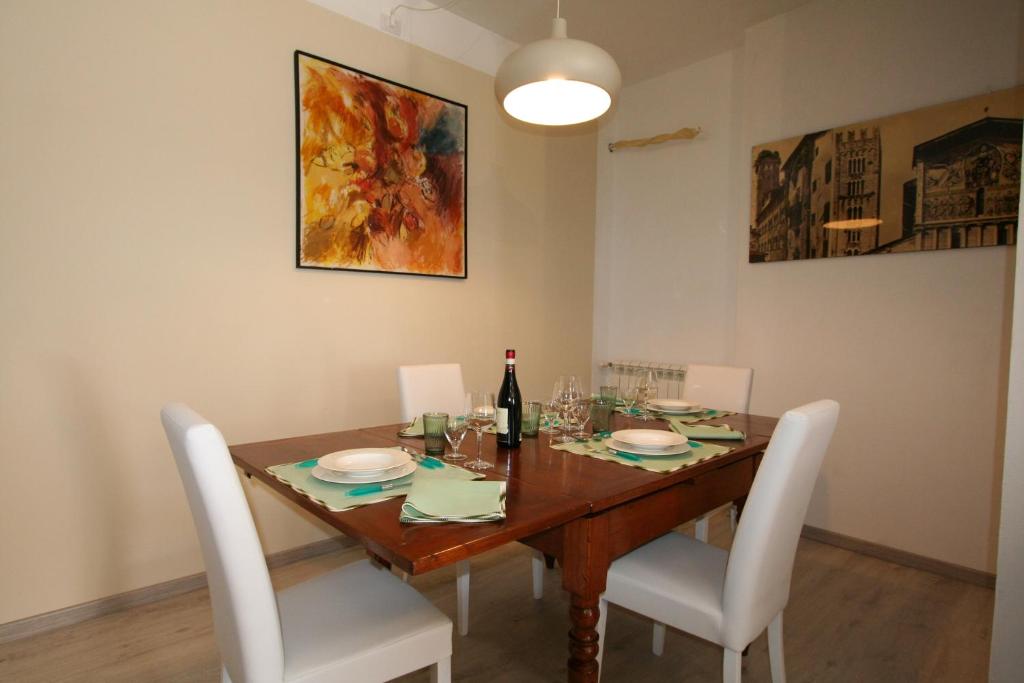 a dining room table with white chairs and a bottle of wine at The Old Laundry in Lucca
