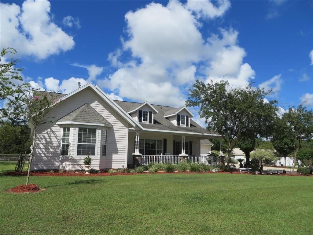 una casa bianca con un prato verde di Rock Pointe Ranch a Floral City