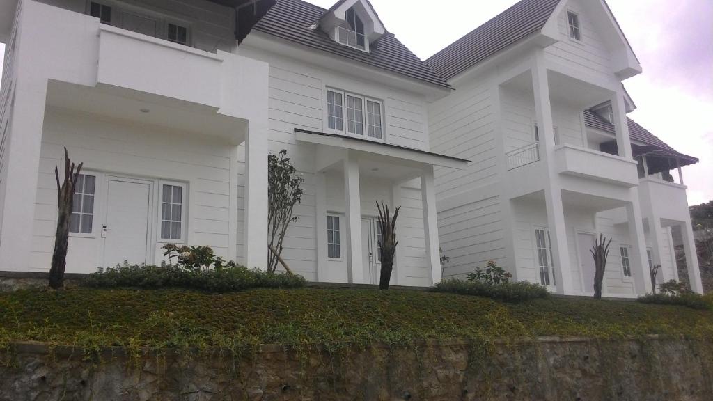 een wit huis met een muur bij Amaranta Guest House in Batu