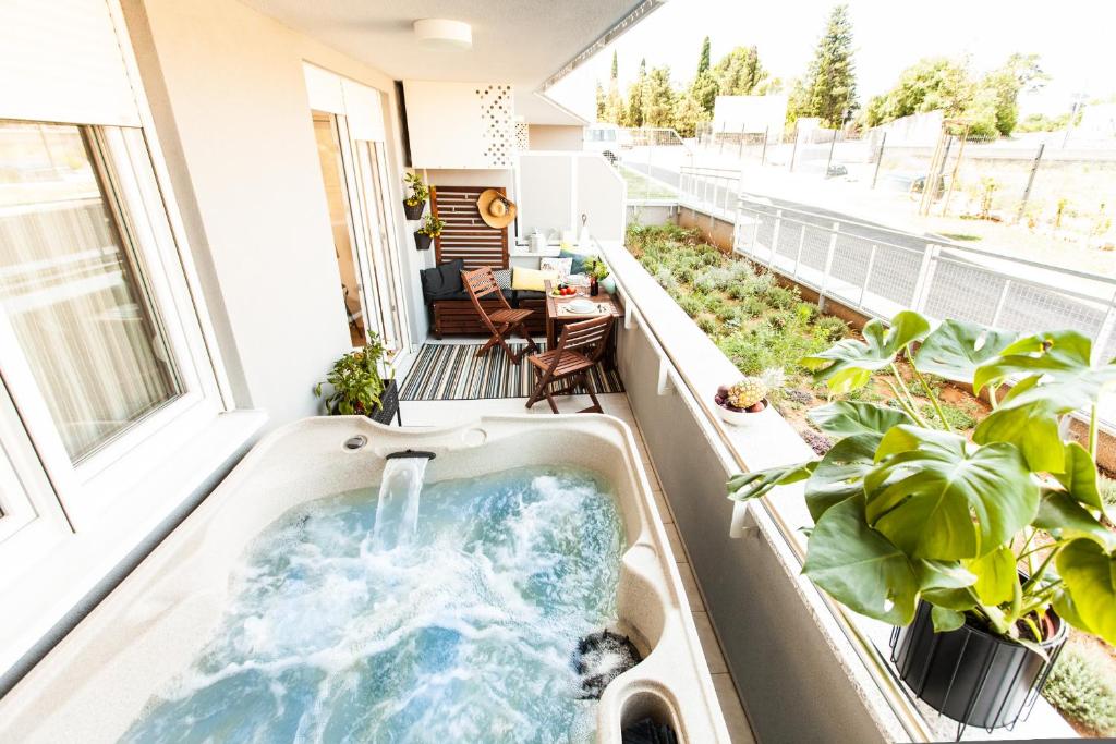 bañera de hidromasaje en un balcón con plantas en Harmony Trsat en Rijeka