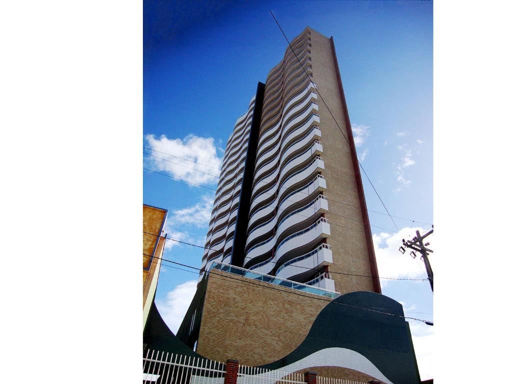un edificio alto con una scultura di fronte di Studio Iracema a Fortaleza