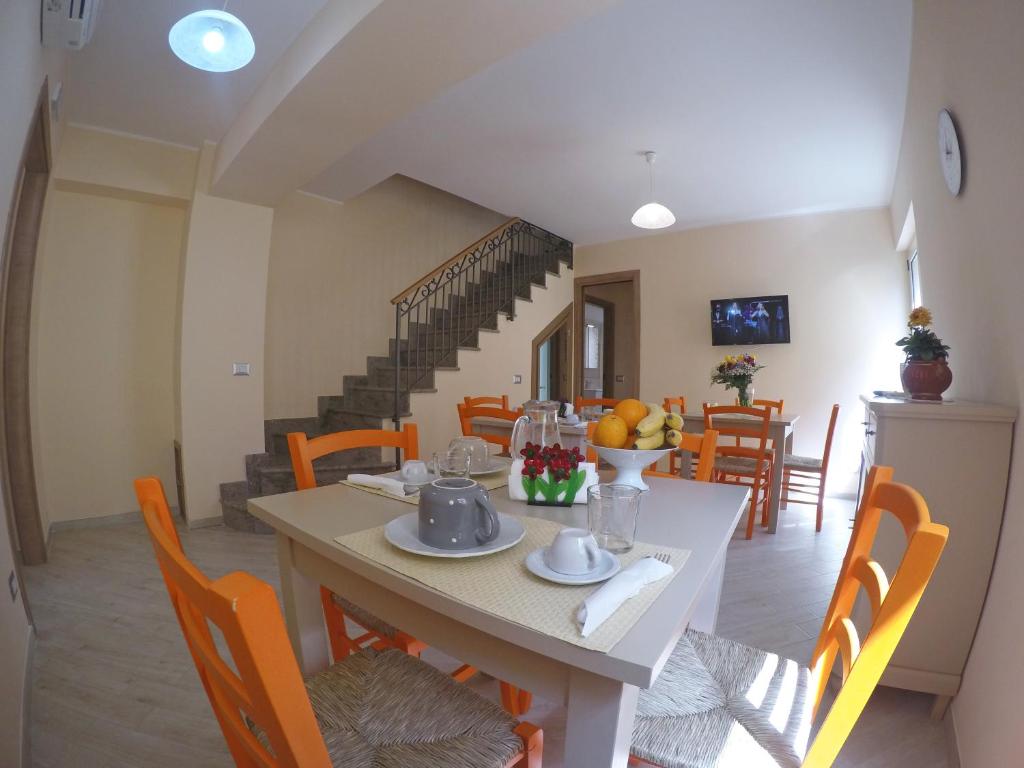 a dining room with a table and chairs and a staircase at BB Aretè in Scilla