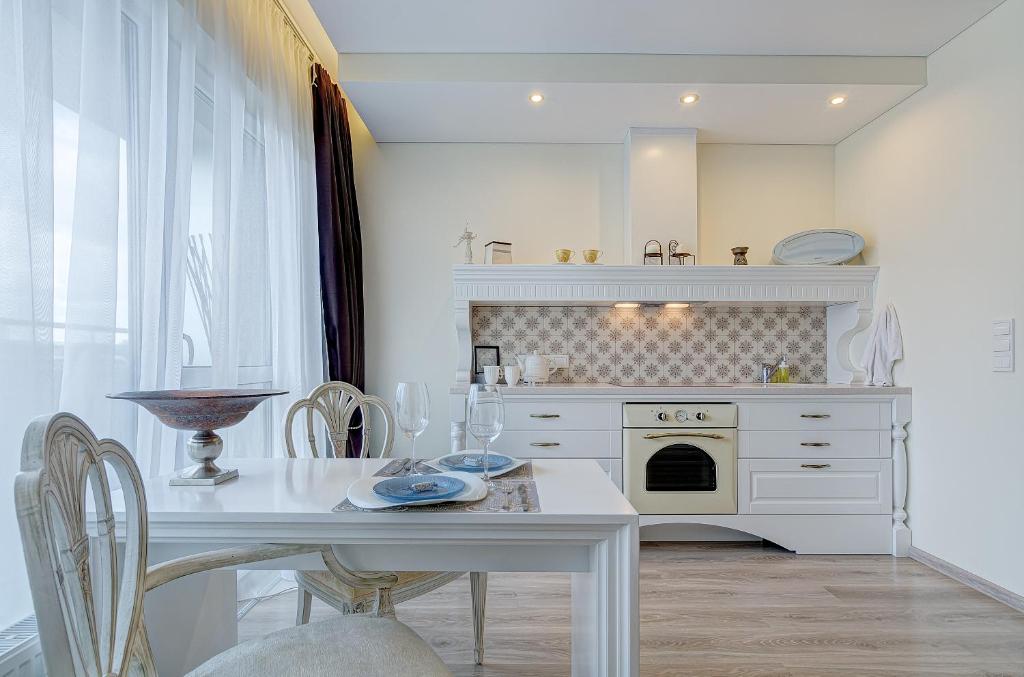 維爾紐斯的住宿－Bright apartment near Akropolis，白色的厨房配有白色的桌子和炉灶。