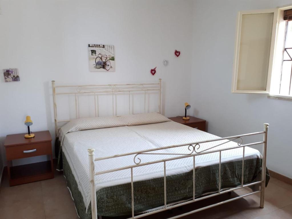 マティーノにあるCasa Vacanze Rosaのベッドルーム1室(白いベッド1台、ナイトスタンド2台付)