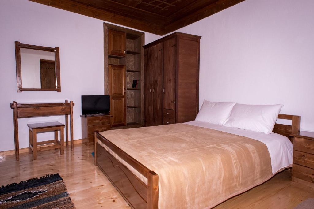 sypialnia z łóżkiem, biurkiem i telewizorem w obiekcie Mossiori Serai w mieście Sitariá