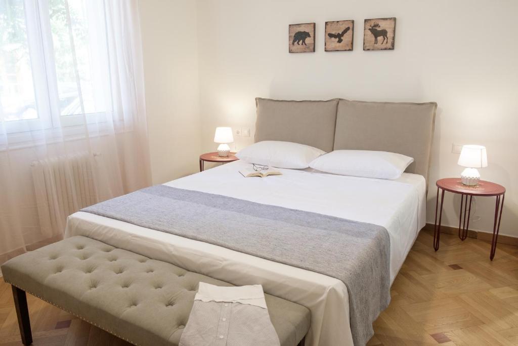 um quarto com uma cama grande e duas mesas em Luxury three bedroom Apartment in Kolonaki em Atenas