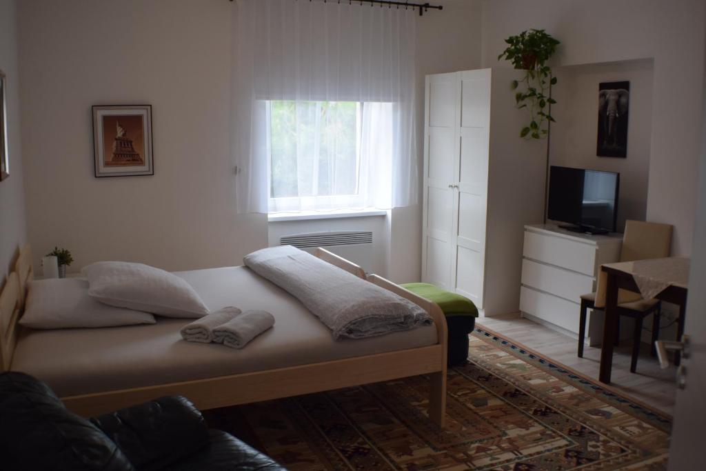 een slaapkamer met een bed met twee handdoeken erop bij Apartmány Lípa in Tábor