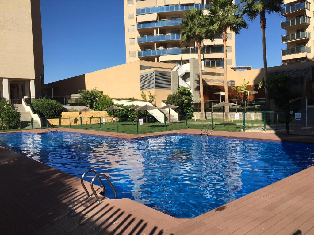 a large blue swimming pool in front of a building at Abedules in El Campello