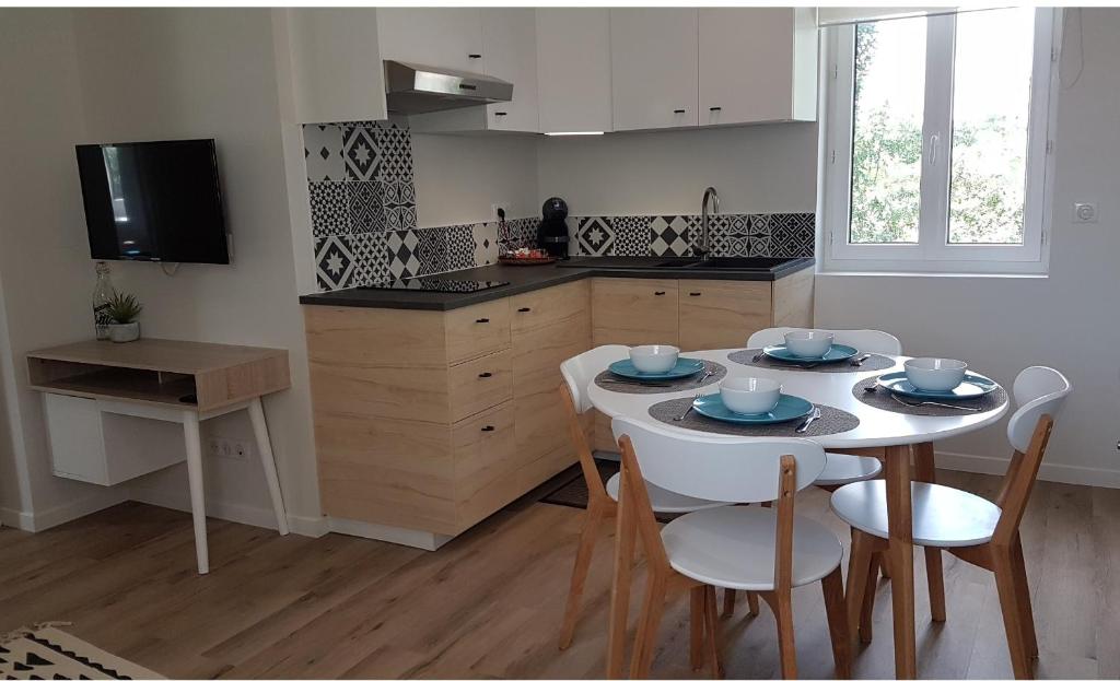 cocina con mesa y sillas y cocina con TV en CDG Aparts en Le Mesnil-Amelot