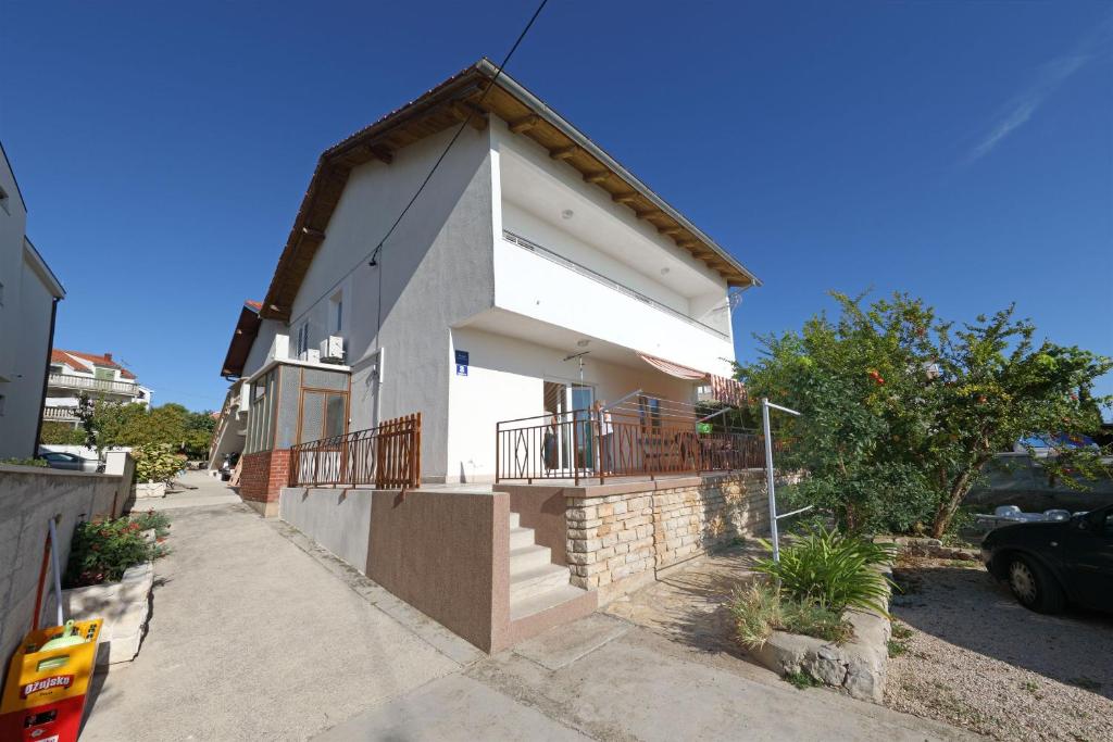 a white house with a balcony on a street at Apartment Ante in Vodice