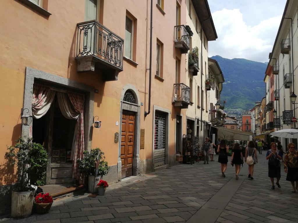 un grupo de personas caminando por una calle con edificios en appartamento nel centro storico di Aosta con vista sui ghiacciai en Aosta