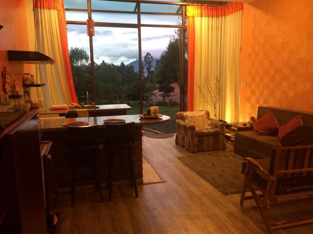 sala de estar con ventana grande, mesa y sillas en NUESTRA CASA - OUR HOME Suite-Studio Cuenca by A2CC, en Cuenca