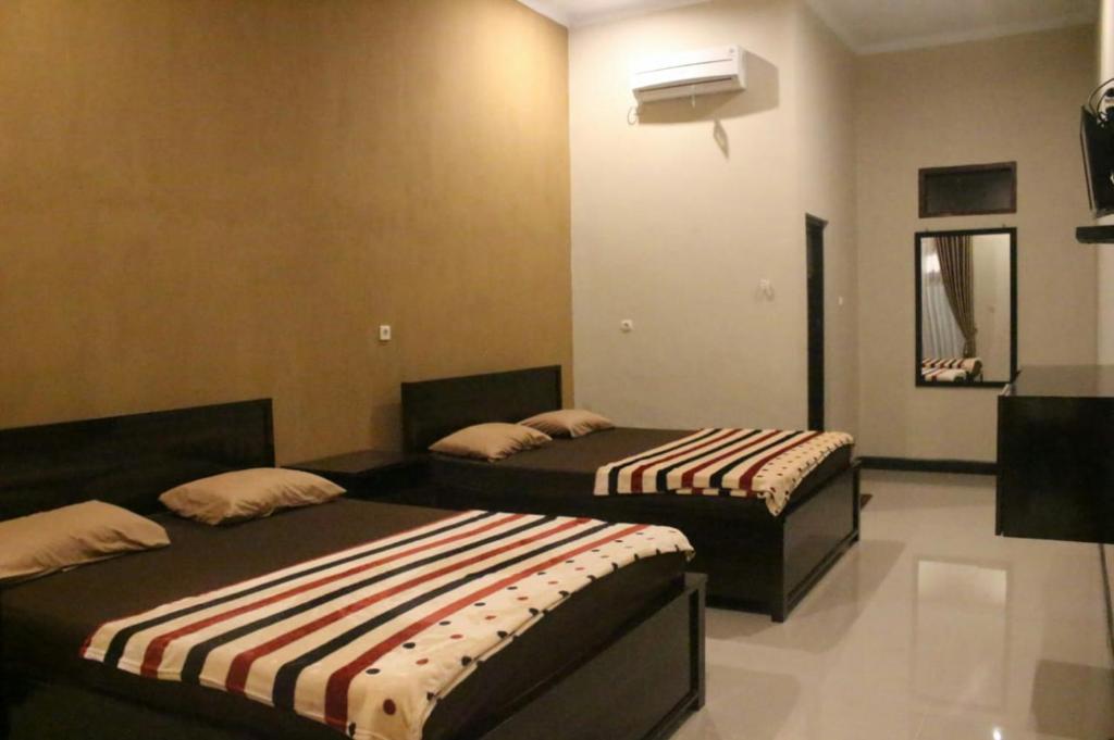 duas camas sentadas num quarto com em Sederhana Homestay em Batukaras