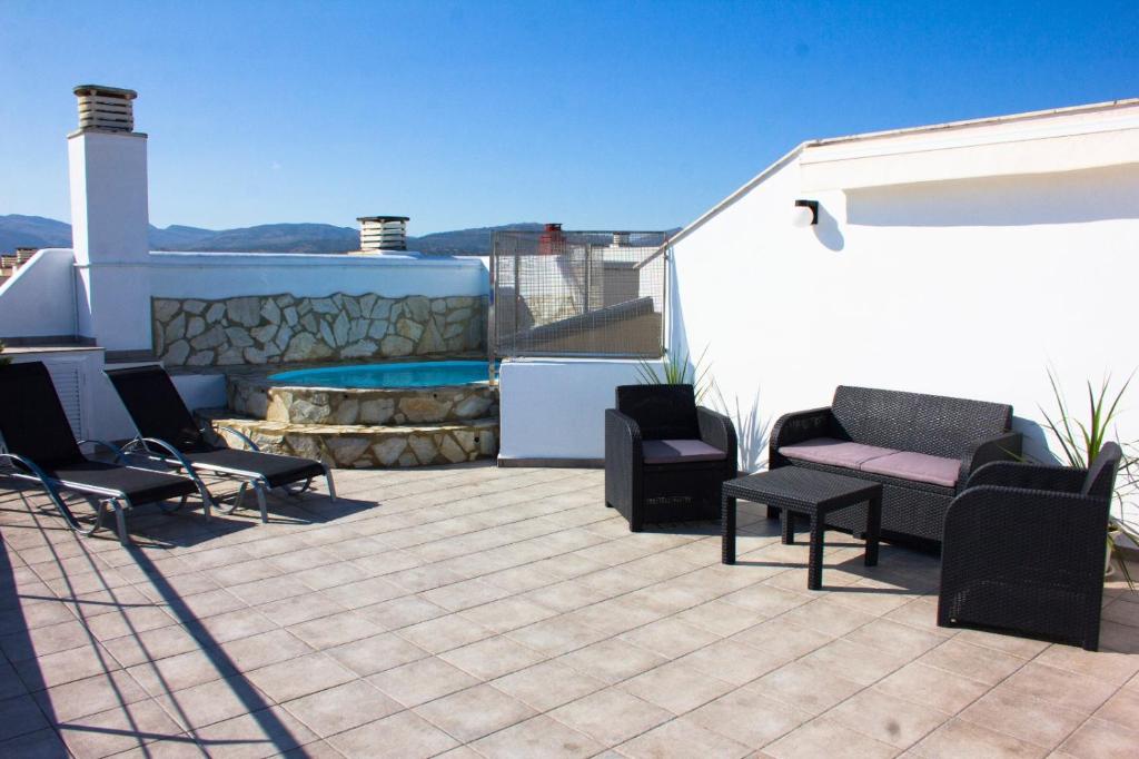eine Terrasse mit Stühlen und einem Pool auf einem Haus in der Unterkunft Puerta De Ronda in Ronda