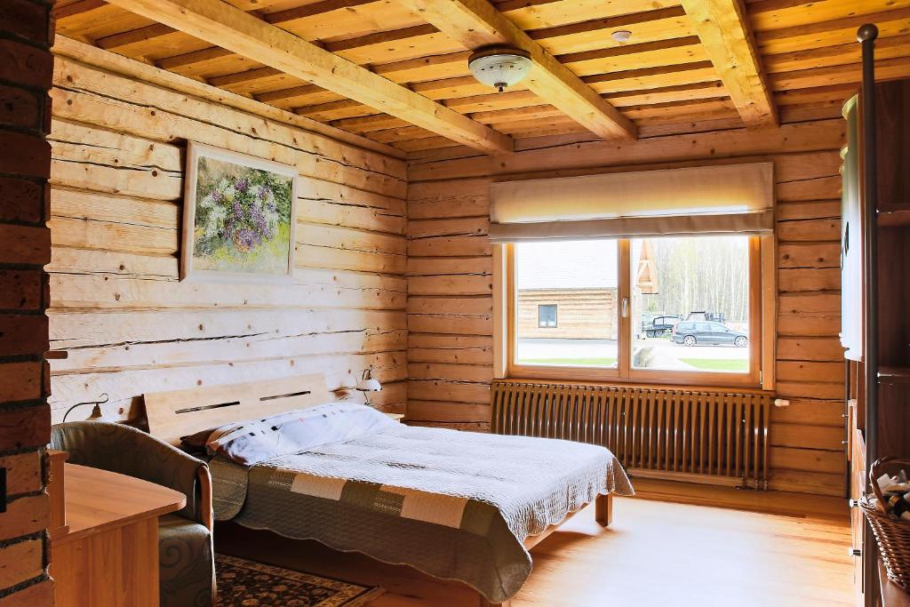 een slaapkamer met een bed in een houten kamer bij Amoliņi in Mērsrags
