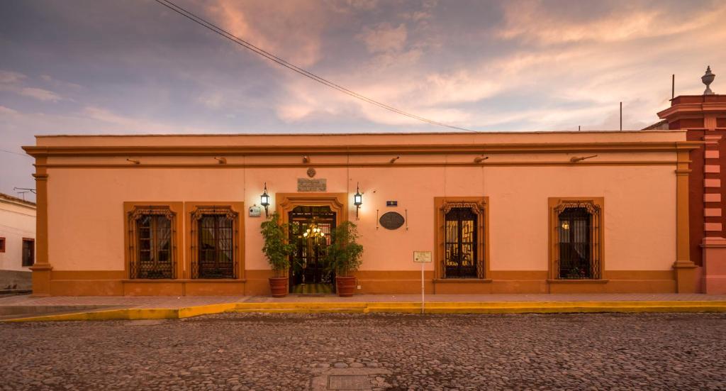 a white building with doors and windows on a street at Santa Elena Hotel Boutique in Mascota