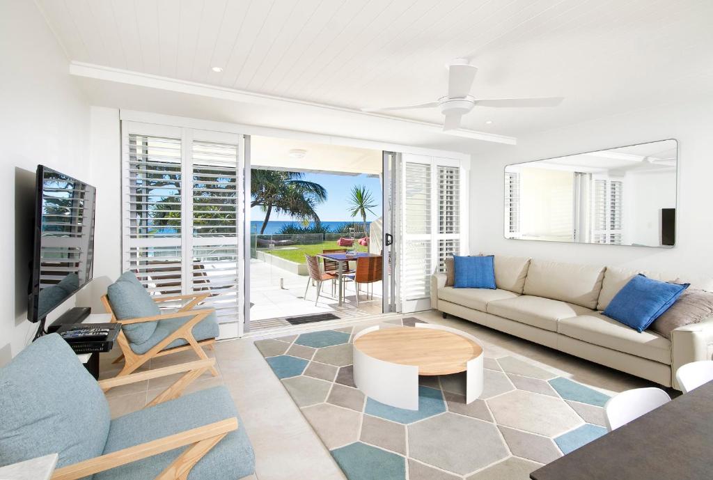 a living room with a couch and a table at Fairshore Apartment 15, Noosa Heads in Noosa Heads