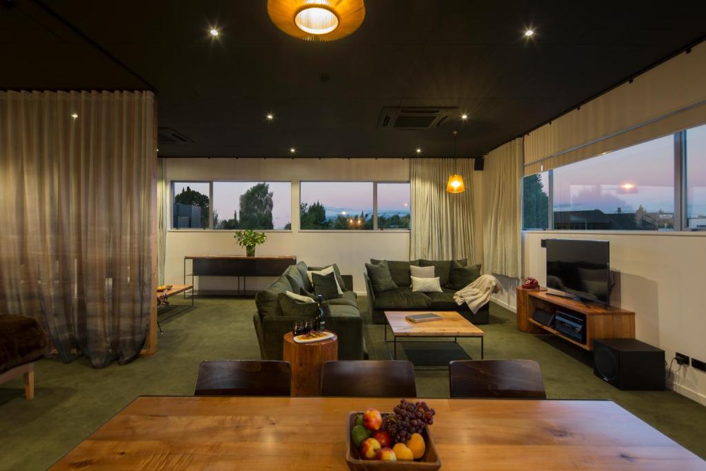 - un salon avec un canapé et une table dans l'établissement The Cinema Suites, à Te Anau
