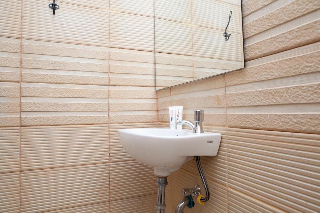 un lavandino bianco in un bagno con pareti in legno di RedDoorz Plus near Pasundan University a Bandung