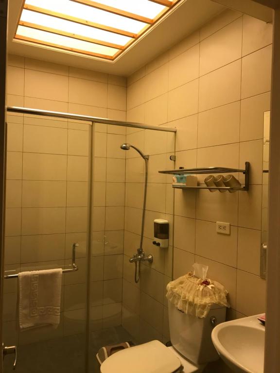 a bathroom with a shower and a toilet and a sink at Kuo Kuang Hostel in Hualien City