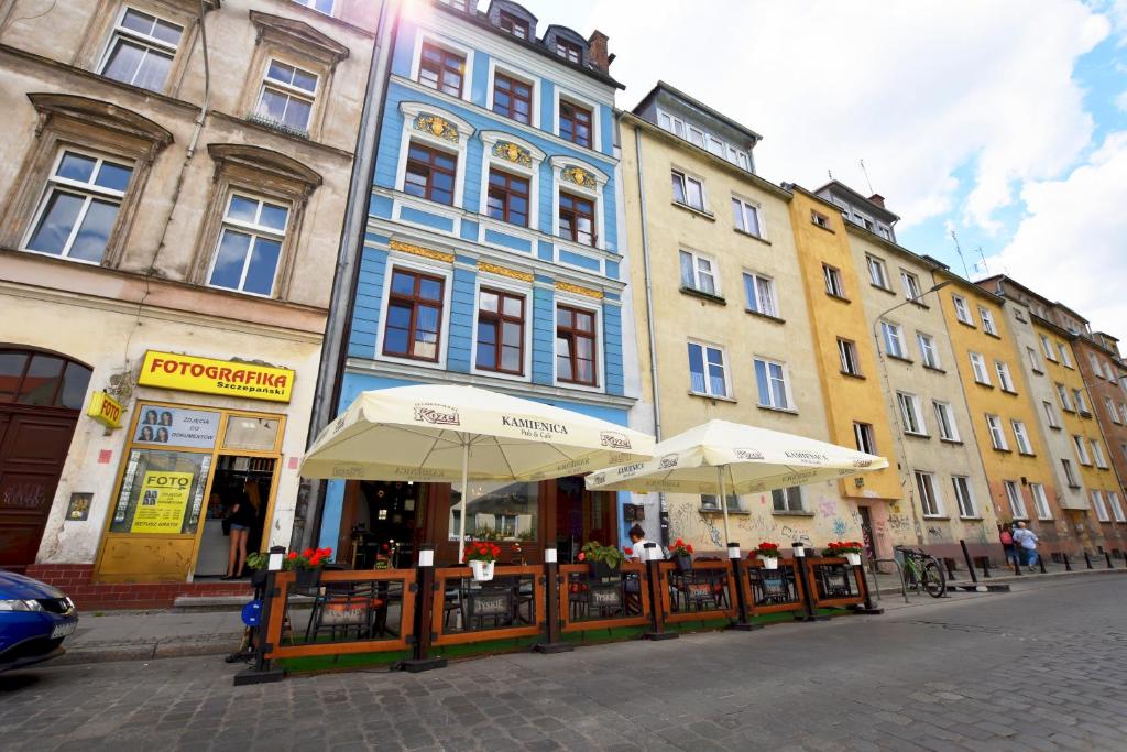un grupo de edificios con sombrillas en una calle de la ciudad en City Central Hostel - Pokoje prywatne, en Wroclaw